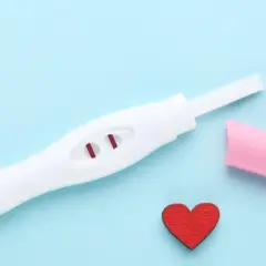 Test ciążowy z dwoma czerwonymi kreskami i serduszkiem. Kiedy najlepiej zrobić test ciążowy? Odpowiedź może być blisko.