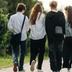 Czterech przyjaciół idzie chodnikiem, ciesząc się wolnością po zakończeniu roku szkolnego 2026.