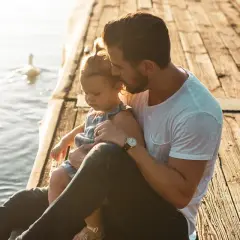 Ojciec tuli córkę na pomoście. Mimo rozstania, prawa ojca do dziecka bez ślubu są widoczne w tej czułej chwili.