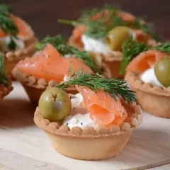 Eleganckie przystawki na komunię: kruche babeczki z łososiem, serkiem, oliwką i koperkiem.
