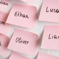 Różowe karteczki z wypisanymi popularnymi amerykańskimi imionami żeńskimi: Ethan, Lucas, Liam, Oliver, Noah, William.