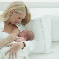 Kobieta karmi piersią noworodka. Karmienie piersią może być przyczyną braku okresu.