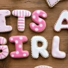 Różowe ciasteczka z lukrem tworzą napis "IT'S A GIRL!". Idealne na baby shower, jak i do wyboru szczęśliwe imiona dla dziewczynek.