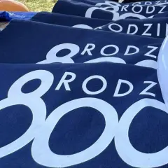 Granatowe koszulki z napisem "RODZINA 800 plus" i biały frisbee z logo 800 plus.
