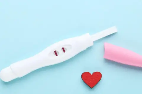 Test ciążowy z dwoma czerwonymi kreskami i serduszkiem. Kiedy najlepiej zrobić test ciążowy? Odpowiedź może być blisko.
