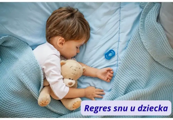 Małe dziecko śpi z misiem i smoczkiem. Czasem pojawia się regres snu u dziecka, ale teraz jest spokojnie.