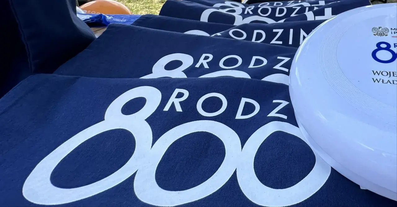Granatowe koszulki z napisem "RODZINA 800 plus" i biały frisbee z logo 800 plus.