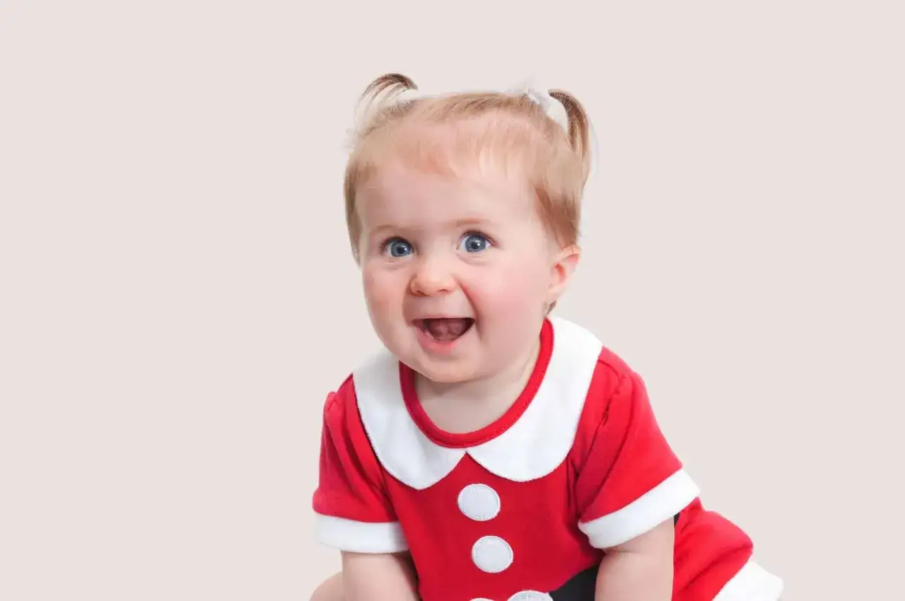 Uśmiechnięta dziewczynka w stroju Mikołaja, z kucykami. Może to przyszła Anneliese lub Greta?
