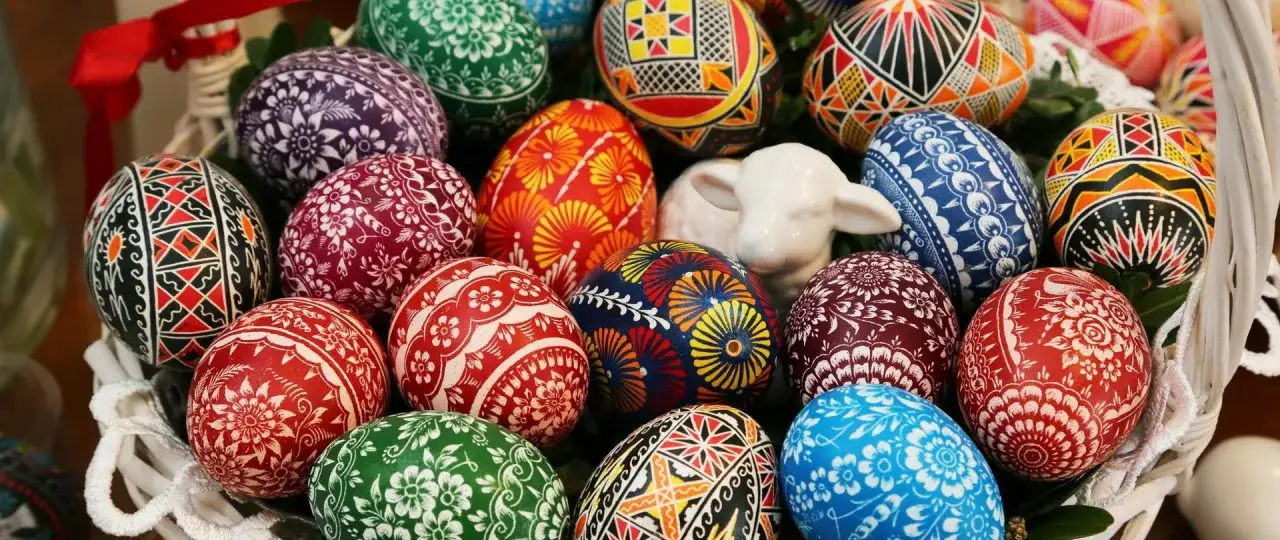 Kosz z pisankami i barankiem. Kolorowe, ręcznie zdobione jajka symbolizują co to jest Wielkanoc – odrodzenie i nadzieję.